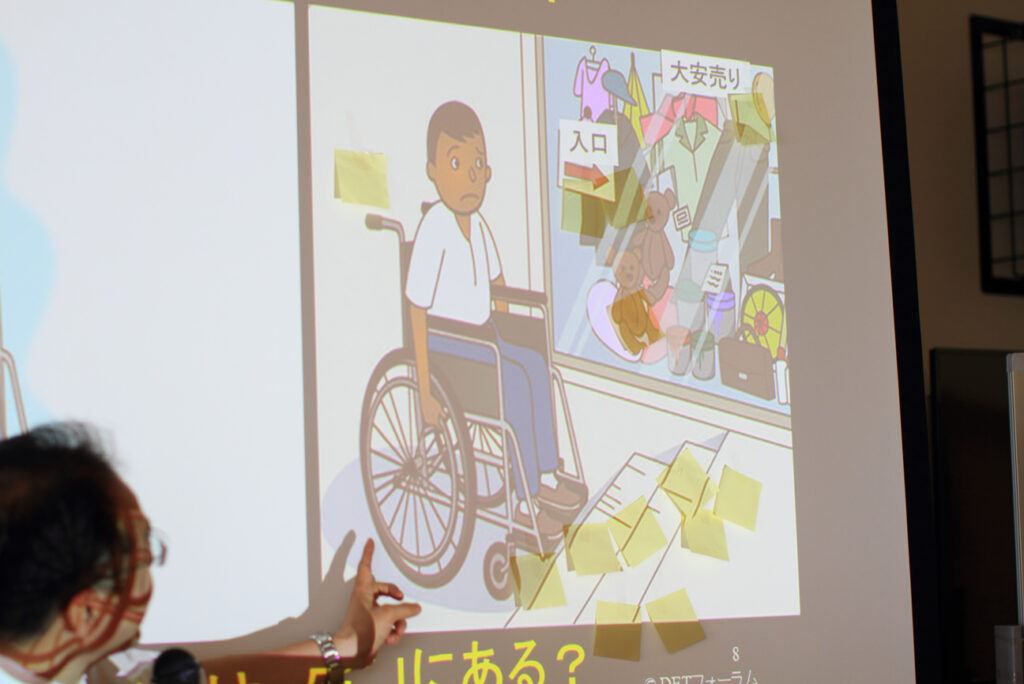 養成講座２回目講師がスクリーンに貼られた付箋について全体に説明している
